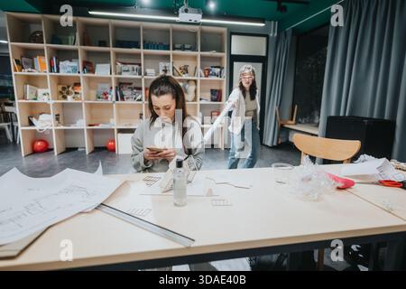 Two Women Collaborating on Creative Projects in a Modern Collaboration Center Studio Stock Photo
