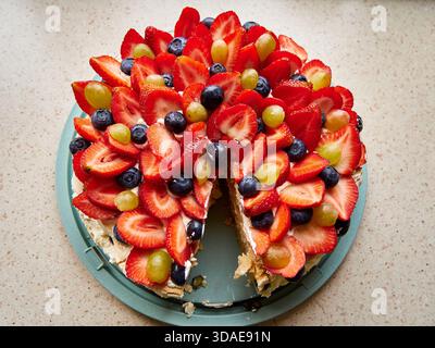 Homemade Pavlova cake topped with fresh strawberries, blueberries and grapes Stock Photo