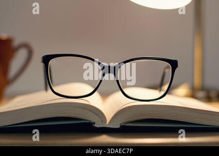 Reading glasses lying on the open book Stock Photo