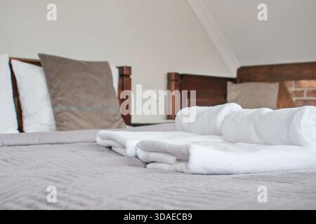 Stack of towels on the bed in hotel room Stock Photo