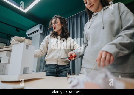 Two students collaborate in a design workshop to build a scale model and prototype Stock Photo