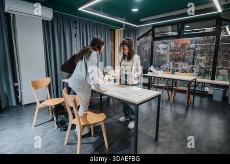 Students collaborate on a project in a modern classroom during a group study session Stock Photo