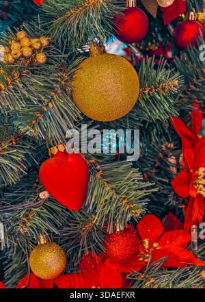Christmas Decorations with Gold Bauble, Red Heart Ornament, and Poinsettias on Festive Tree Happy New Year Background Stock Photo