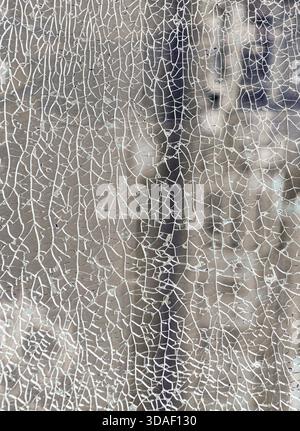 Newcastle, UK - Apr 11, 2025 - Detail of cracked broken glass cracks by impact. Cracked on the glass surface background. Texture of broken tempered gl Stock Photo
