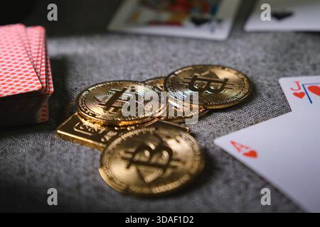 Bitcoin coins stacked on a table with playing cards, symbolizing crypto gambling risk Stock Photo