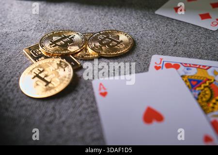 Bitcoin cryptocurrency coins and casino playing cards on a gray fabric surface Stock Photo