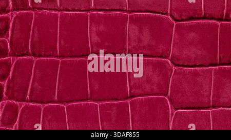 Close-up of luxurious lava red crocodile leather texture with bold rectangular embossing and glossy finish. Natural background for fashion design, mat Stock Photo