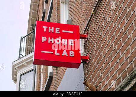 Mobile phone repair shop sign mounted on brick building exterior in an urban street Stock Photo