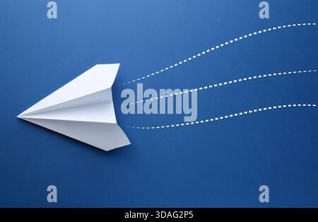 Paper plane with dotted lines as air route track on blue background Stock Photo