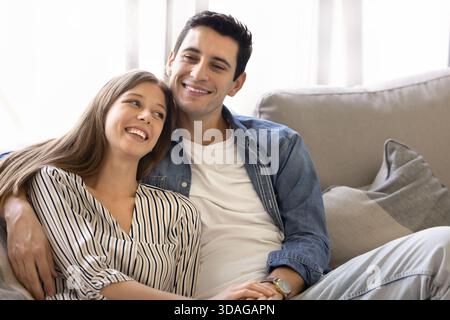 Beautiful couple relaxing together on sofa at home Stock Photo