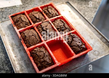 Brownies baking in a red silicone mold on a metal oven tray Stock Photo