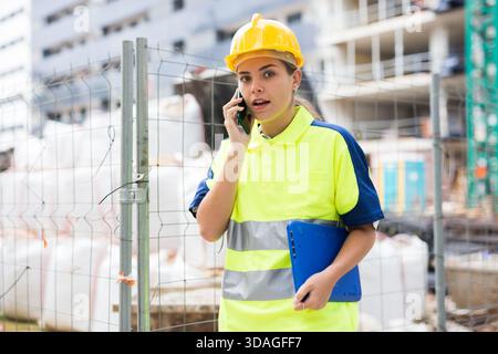 Builder woman talking on phone Stock Photo