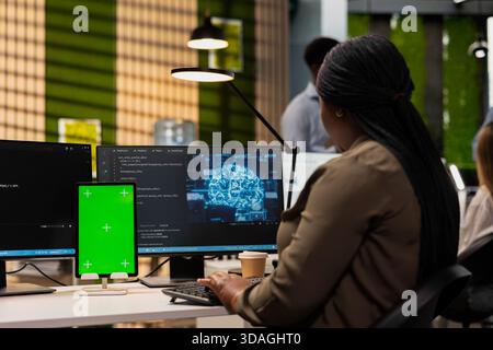 Engineer writing code on green screen tablet, developing machine learning APIs. Admin using chroma key device to troubleshoot software errors using artificial intelligence Stock Photo
