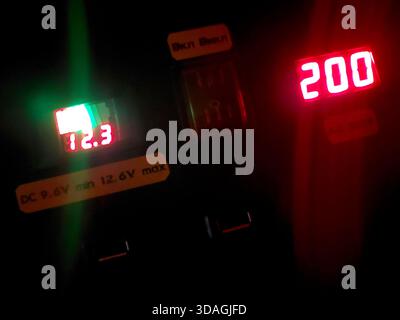 A display shows power levels and indicators on a charging stations electrical panel. The figures represent current usage and voltage levels. Stock Photo