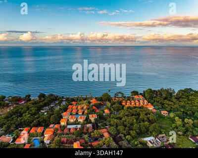 Beautiful sunset over the ocean and coastal resorts in Tulamben, Bali Stock Photo