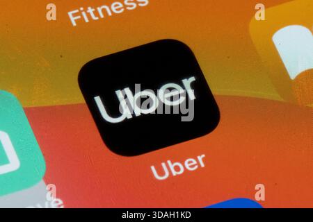 A close-up shot of the Uber app icon displayed on a smartphone screen. Stock Photo