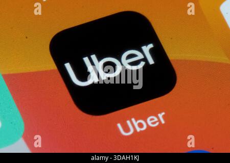 A close-up shot of the Uber app icon displayed on a smartphone screen. Stock Photo