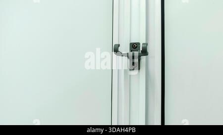 Modern Gray Plastic Shower Hook or Door Accessory Mounted on White Vertical Panel or PVC Partition Stock Photo