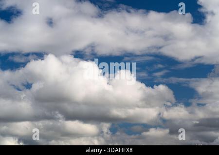 A truly picturesque view of fluffy white clouds floating gracefully against a vibrant deep blue sky Stock Photo