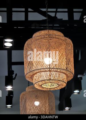 Cozy brown woven lamp hangs in modern rustic interior. warm light from decorative pendant creates an ambient and peaceful atmosphere for home design a Stock Photo