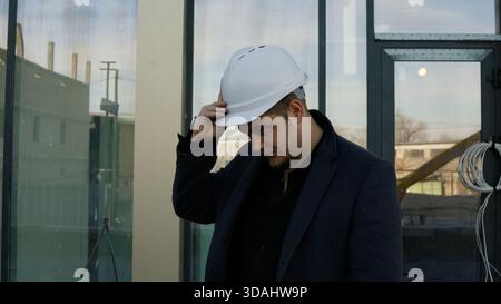 Focused architect engineer examines the building structure outdoors Stock Photo