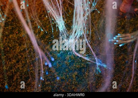 Abstract glowing fiber optic background shows magical network of colorful light strands, creating sense of ethereal connection and futuristic technolo Stock Photo