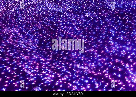 Glowing purple and blue abstract background of light sparkle with bokeh effect. An enchanting violet display perfect for magical night scene or festiv Stock Photo