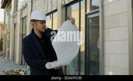 Two engineers or architects discussing plans on a construction site outdoors Stock Photo