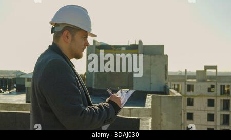 Serious construction manager in hard hat using a tablet for site inspection Stock Photo