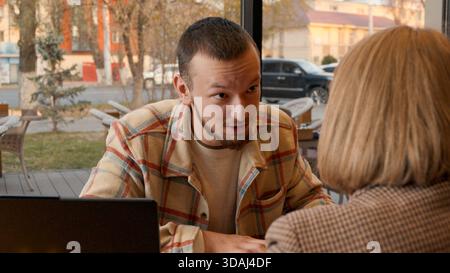 Happy couple or friends discussing ideas in a relaxed setting with notebooks Stock Photo