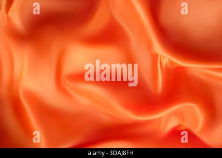 Orange color satin draped fabric as an abstract background Stock Photo