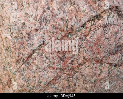 Natural stone granite background texture. Bright hard red granitic rock texture. Stock Photo