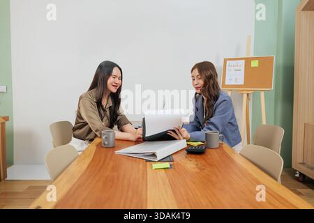 Busy office women meet, people discussing work documents and market strategy, demonstrating Stock Photo
