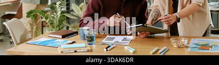 Young Adult Caucasian Woman Assisting Middle Aged Black Man Using Digital Tablet Stock Photo