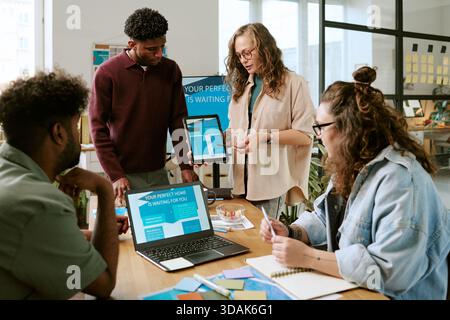 Diverse Young Adults Collaborating during Creative Office Meeting Stock Photo