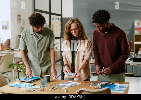 Young Multiethnic Colleagues Collaborating on Project in Modern Office Setting Stock Photo