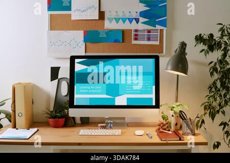 Contemporary Workspace Featuring Computer Displaying Property Search Website Stock Photo