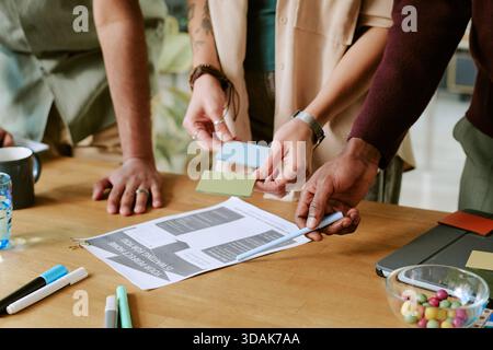 Multiethnic Young Adults Collaborating on Creative Project at Office Table Stock Photo