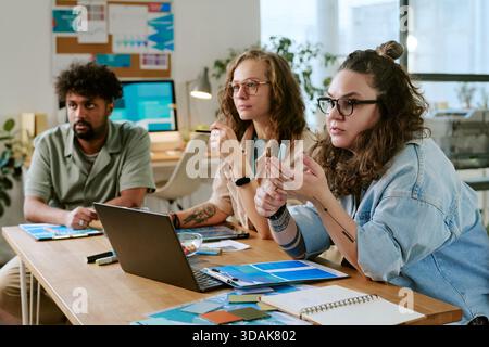 Multiethnic Young Adults Collaborating during Business Meeting in Office Stock Photo