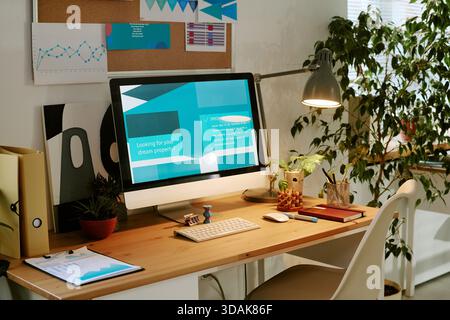Modern Home Office Desk Featuring Computer Displaying Real Estate Website Stock Photo