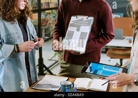 Young Adult Multiethnic Team Collaborating during Real Estate Presentation Stock Photo