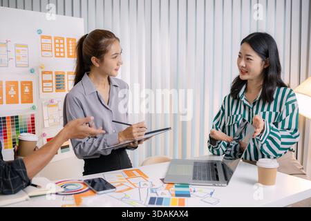 UX/UI designers collaborating during a creative workshop to test interface ideas and exchange feedback for app development, emphasizing teamwork and i Stock Photo