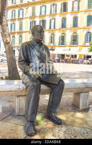 Malaga, Spain - September 12, 2024: Statue of Pablo Picasso. Bronze statue of a man seated on a bench, in front of a building. Stock Photo