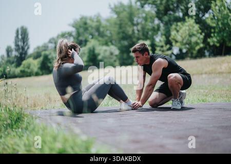 Personal Trainer Assists Woman with Outdoor Fitness Exercise Stock Photo