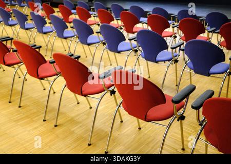 Row of red and blue chairs. Conference room. France. Stock Photo
