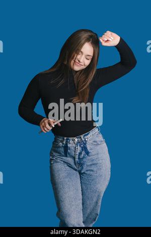 Female Dancer Lively, Energetic Woman In Relaxed Fashion Striking Graceful Pose During Photoshoot Stock Photo