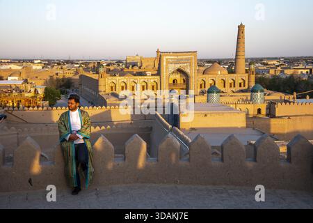 Young Uzbek wearing traditional coat in Itchan Kala, Khiva old city, Uzbekistan Stock Photo