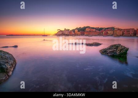 Long exposure sunset over the Bay of Silence, Baia del Silenzio, in Sestri Levante, Liguria, Italy. Rocks in the foreground, and the promontory is ill Stock Photo