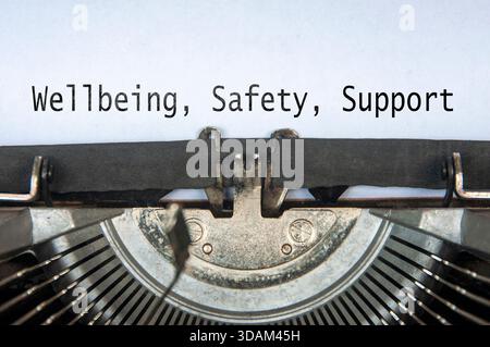 Wellbeing, Safety and Support text on old typewriter. Stock Photo