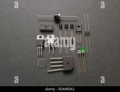 Various semiconductor components on a black. Transistors, voltage regulators, diodes. Stock Photo
